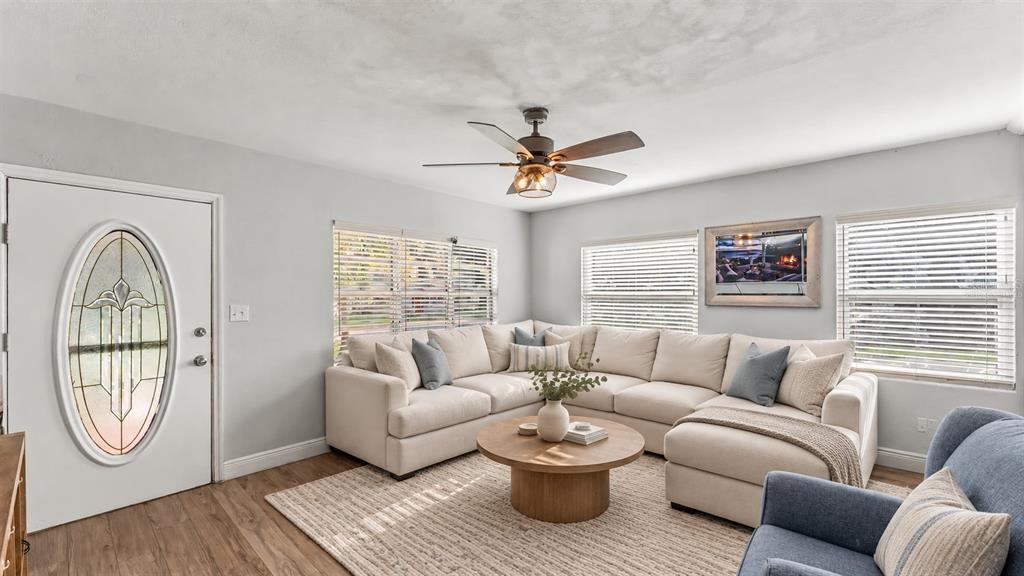 A kitchen features granite countertops, white cabinetry, a stainless steel refrigerator, and a black curtain — 861 E LOWELL STREET, LAKELAND, FL