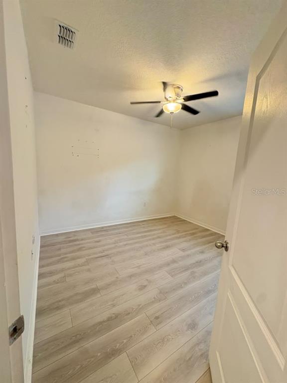 A laundry room with white tile floors, a washer, a dryer, and a hallway beyond — 329 WINGED ELM DRIVE, DEBARY, FL