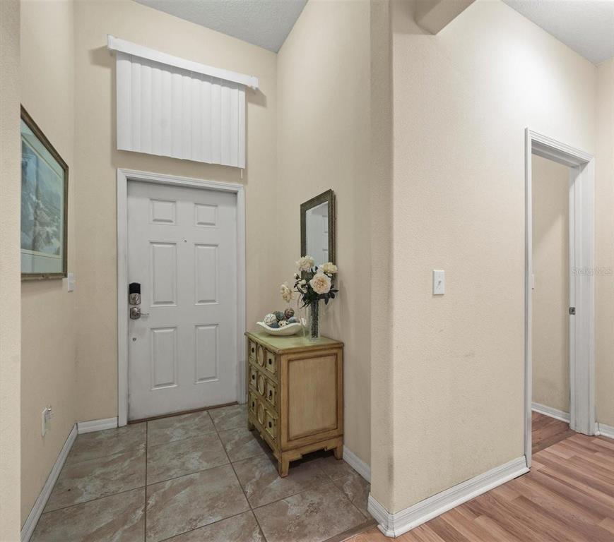An entryway features a white front door, tile flooring, and a small wooden cabinet — 12722 DRAKEFIELD DRIVE, SPRING HILL, FL