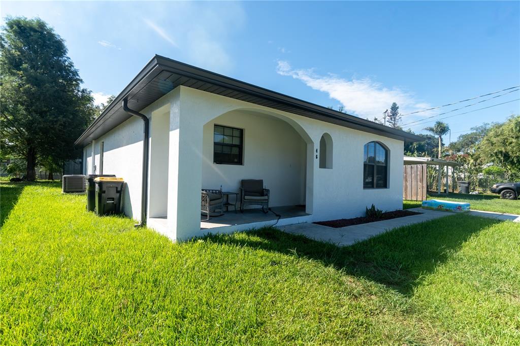 A white house with a covered porch, dark trim, and a grassy yard — 146 8TH STREET, WINTER HAVEN, FL