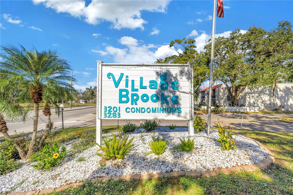 A sign for Villa Brooke Condominiums stands in a landscaped bed with white gravel — 3269 BENEVA ROAD UNIT 102, SARASOTA, FL