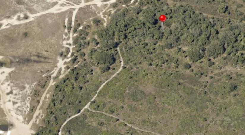 An aerial view shows a red map pin marking a wooded area near dirt paths — 306TH STREET, OKEECHOBEE, FL