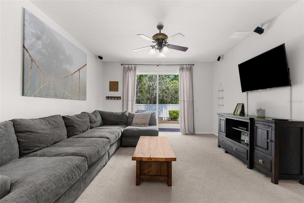 A living room features a large gray sectional sofa, a wooden coffee table, and a television — 14581 WAKE ROBIN DRIVE, BROOKSVILLE, FL