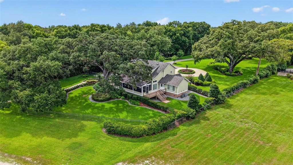 An aerial view shows a two-story house with a large yard and mature trees — 12950 E HIGHWAY 25, OCKLAWAHA, FL