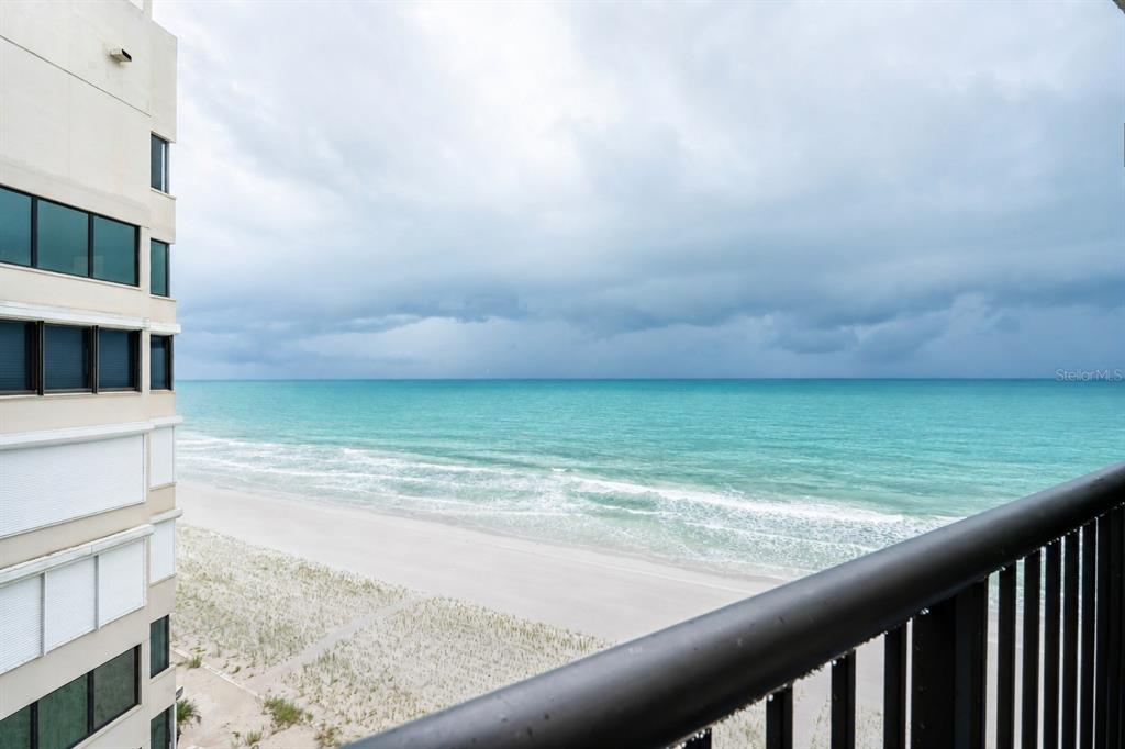 A view of the ocean and beach from a high-rise balcony with a metal railing — 1600 GULF BOULEVARD UNIT 1013, CLEARWATER, FL