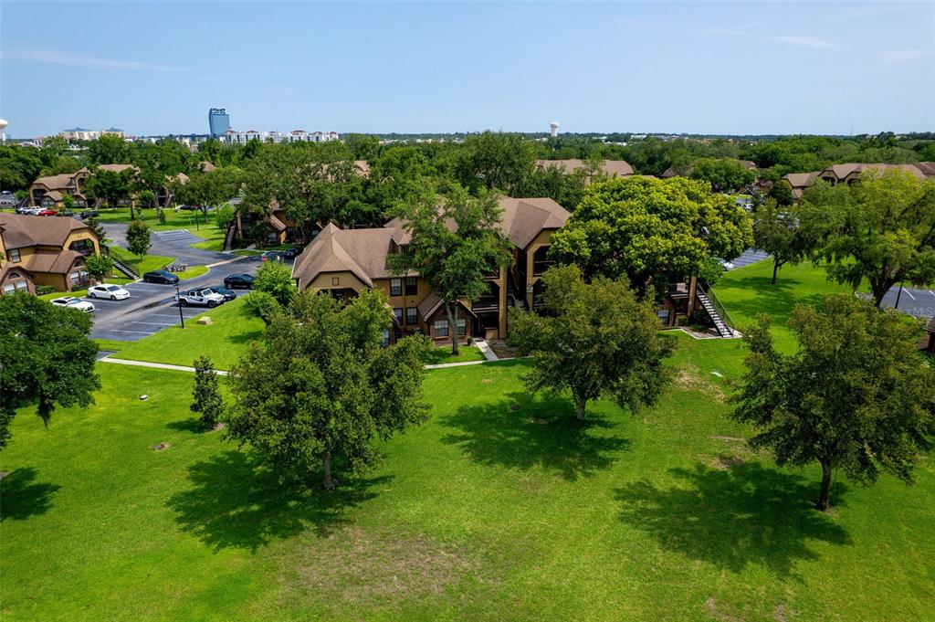 An aerial view shows a multi-story apartment building surrounded by green lawns and parking lots — 420 FORESTWAY CIRCLE UNIT 206, ALTAMONTE SPRINGS, FL