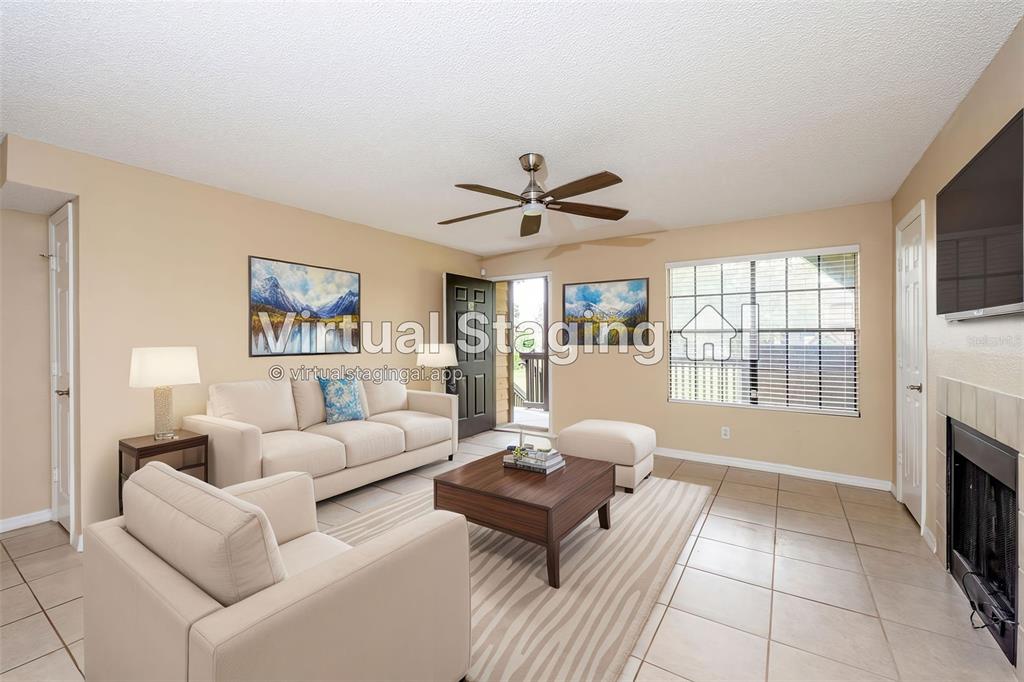 A living room with tile flooring, a fireplace, a ceiling fan, and virtual furniture staging — 420 FORESTWAY CIRCLE UNIT 206, ALTAMONTE SPRINGS, FL