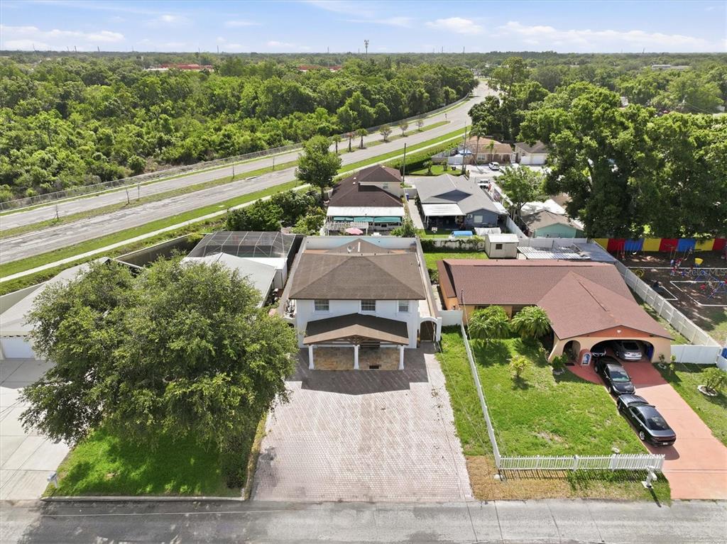An aerial view shows a two-story house with a paved driveway and a neighboring property — 6611 N HALE AVENUE, TAMPA, FL