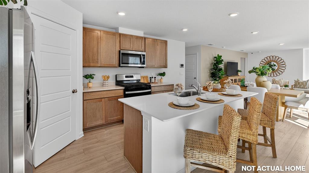 This rendering shows a kitchen with wood cabinets, a white island, and an adjacent dining area — 16 FLAGSTICK LANE, BUNNELL, FL