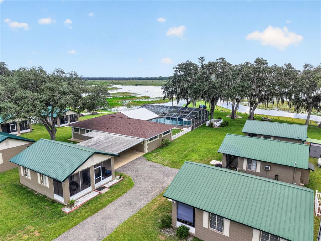 An aerial view shows several small buildings with green metal roofs near a lake — 2489 N LAKEFRONT DRIVE, HERNANDO, FL