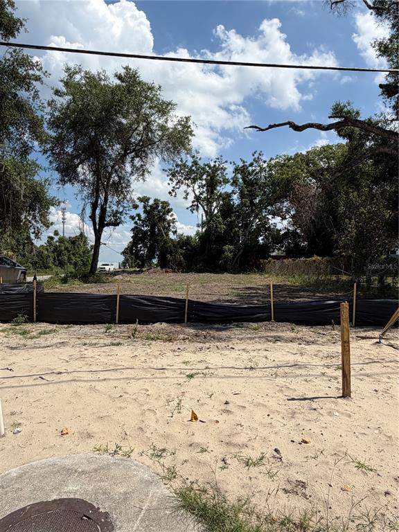 A vacant, sandy lot is enclosed by a black silt fence with trees in the background — 3504 HOGSHEAD ROAD, APOPKA, FL