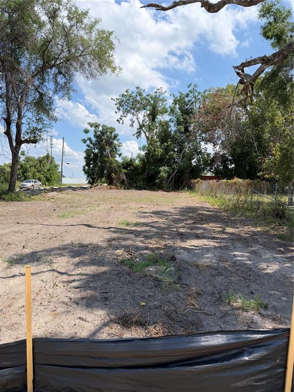 A vacant, cleared lot features sandy soil, scattered vegetation, and mature trees under a blue sky — 3504 HOGSHEAD ROAD, APOPKA, FL