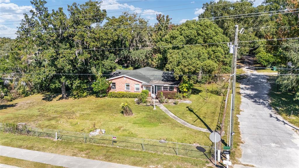 An aerial view shows a single-story brick house with a dark roof on a grassy lot — 5985 W GULF TO LAKE HIGHWAY, CRYSTAL RIVER, FL
