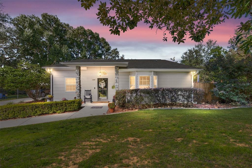 A single-story house with light siding, stone accents, and a front lawn at dusk — 5985 W GULF TO LAKE HIGHWAY, CRYSTAL RIVER, FL