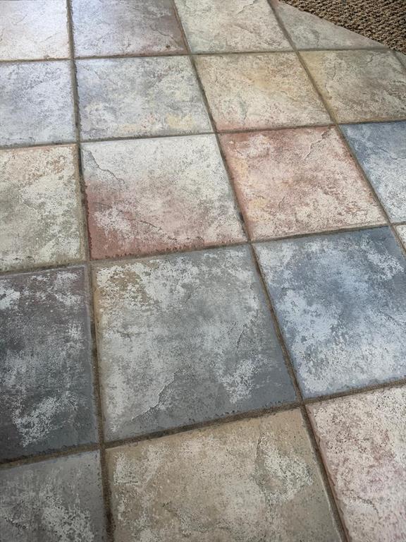 A close-up view of multi-colored, textured square floor tiles with visible grout lines — 471 HOLBORN LOOP, DAVENPORT, FL