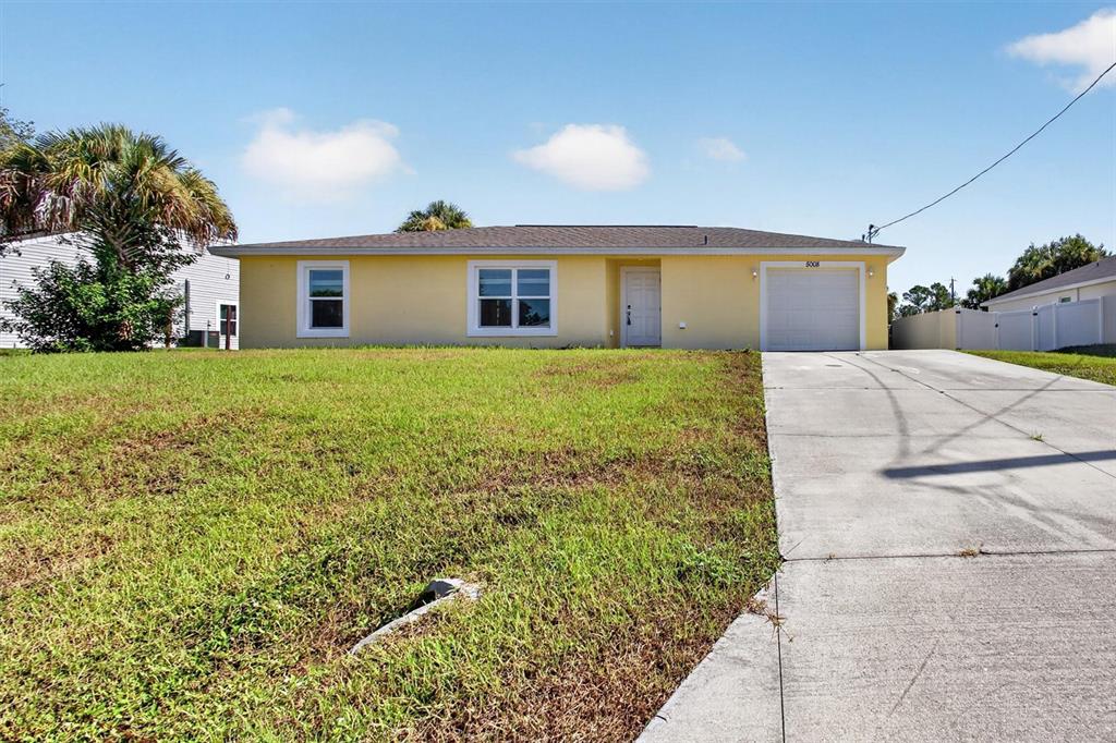 A yellow single-story house features a concrete driveway, a one-car garage, and a front lawn — 5008 S OBISPO CIRCLE, LABELLE, FL