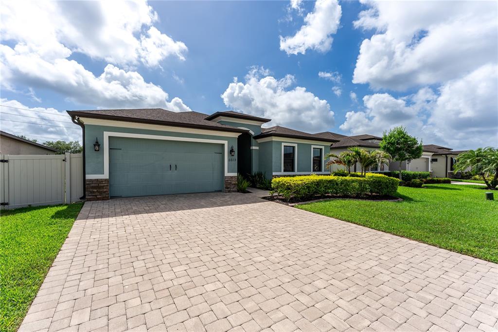 A single-story house with a teal exterior, a two-car garage, and a paved driveway — 6619 35TH COURT E, SARASOTA, FL