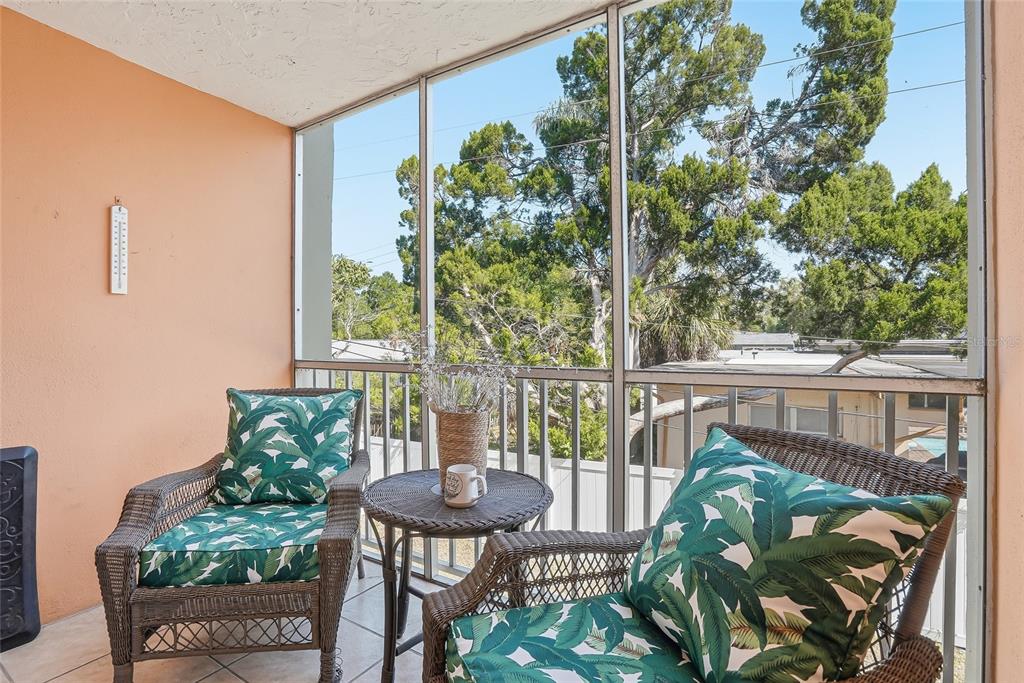 A multi-story apartment building with a covered parking area and several parked cars — 952 VIRGINIA STREET UNIT 202, DUNEDIN, FL