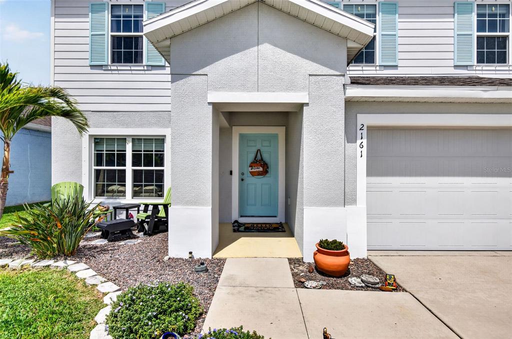 The exterior of a two-story house features a light blue front door and garage — 2161 BRANDING IRON COURT, NEW PORT RICHEY, FL
