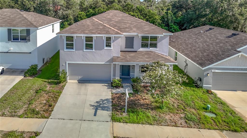 An aerial view of a two-story suburban house with a garage and a paved driveway — 7737 ROSEWOOD GARDEN LOOP, TAMPA, FL