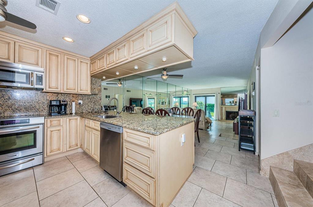 A grassy lawn with palm trees and a pond sits beside a multi-story building — 6260 SUN BOULEVARD UNIT 1, ST PETERSBURG, FL