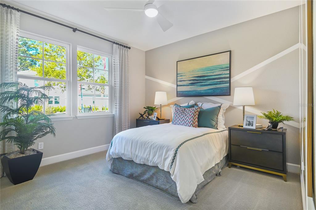 A bedroom features a bed with white bedding, two nightstands, and a wall with geometric accents — 204 THORNBERRY WAY, PALM COAST, FL