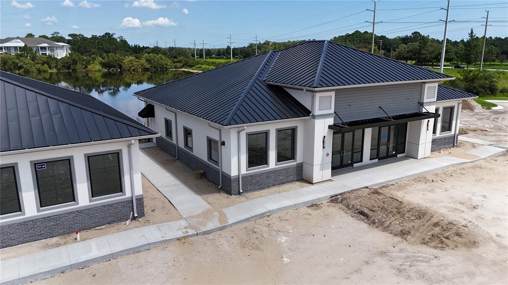 An exterior view of a building under construction with a dark metal roof and scaffolding — 30 EXCHANGE LOOP LOOP UNIT 7, PALM COAST, FL
