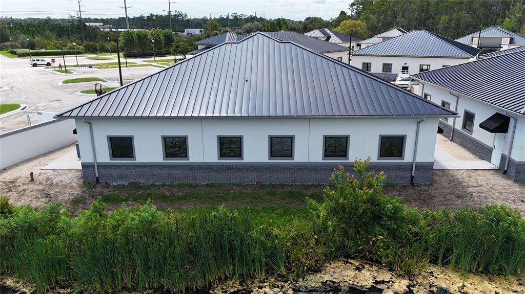 An exterior view of a concrete block building under construction with a dark metal roof — 30 EXCHANGE LOOP LOOP UNIT 7, PALM COAST, FL