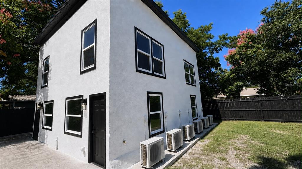 A two-story white building with black trim and multiple exterior air conditioning units — 327 AVENUE J SE, WINTER HAVEN, FL