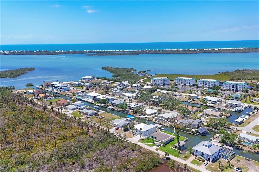 An aerial view shows a waterfront house with a boat dock in a coastal neighborhood — 9201 LAKE DRIVE, ENGLEWOOD, FL