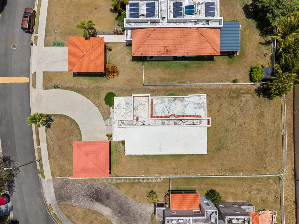 An aerial view shows several houses with orange tile roofs and carports in a neighborhood — 106 MORNING DEW G-14, SUNRISE AT PALMAS DEL MAR, HUMACAO, PR