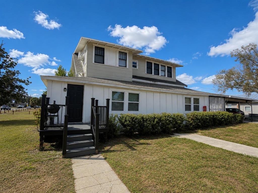 A two-story house with beige siding, black trim, and an upper-level balcony — 1339 7TH STREET SW, WINTER HAVEN, FL