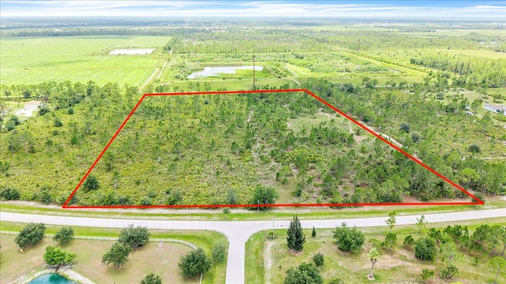 An aerial view shows a large, rectangular vacant lot outlined in red near a road — 3601 HIDDEN VALLEY CIRCLE, PUNTA GORDA, FL