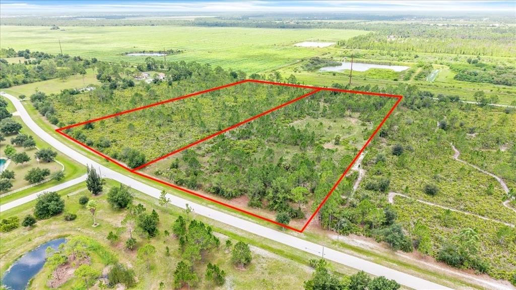 An aerial view shows two adjacent vacant lots outlined in red along a paved road — 3601 HIDDEN VALLEY CIRCLE, PUNTA GORDA, FL