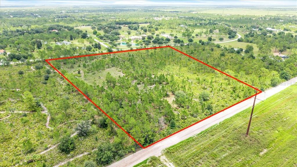 An aerial view shows a rectangular, tree-covered plot of land outlined in red near a road — 3601 HIDDEN VALLEY CIRCLE, PUNTA GORDA, FL