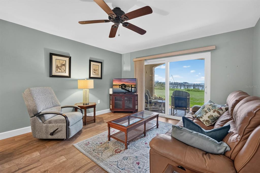 A living room with a leather sofa, recliner, coffee table, and sliding doors to a patio — 7265 A1A S UNIT B8, ST AUGUSTINE BEACH, FL