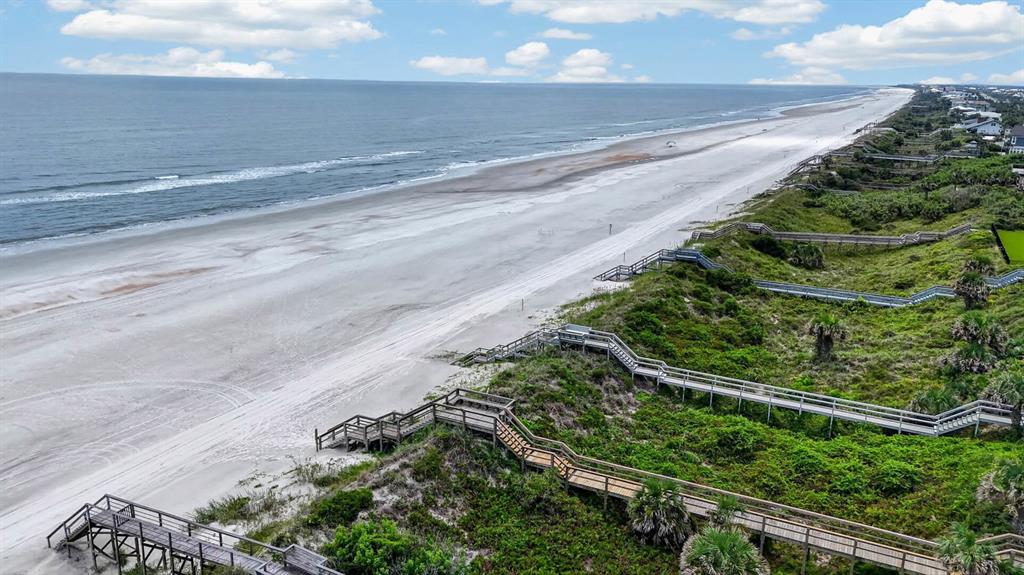 An aerial view shows a sandy beach with multiple wooden boardwalks leading through coastal dunes — 7265 A1A S UNIT B8, ST AUGUSTINE BEACH, FL