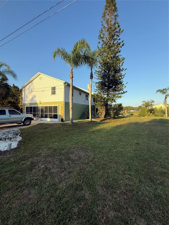 A two-story house with a garage and palm trees stands on a grassy lot — 3338 FERNLEAF DRIVE, HERNANDO BEACH, FL
