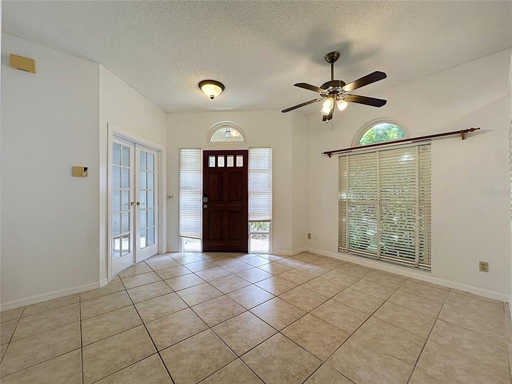 An entryway with tile flooring, a dark wood front door, and a ceiling fan — 1047 KELLY CREEK CIRCLE, OVIEDO, FL