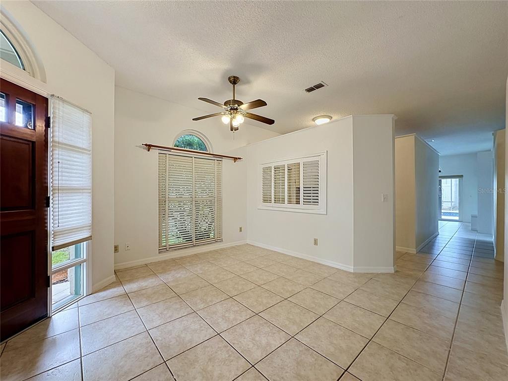 A bright room with tiled floors, a ceiling fan, and windows with white plantation shutters — 1047 KELLY CREEK CIRCLE, OVIEDO, FL
