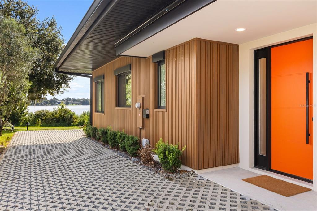 Exterior view of a modern home with vertical wood siding, white stucco, and a paved driveway — 930 EAST BOULEVARD, WINDERMERE, FL