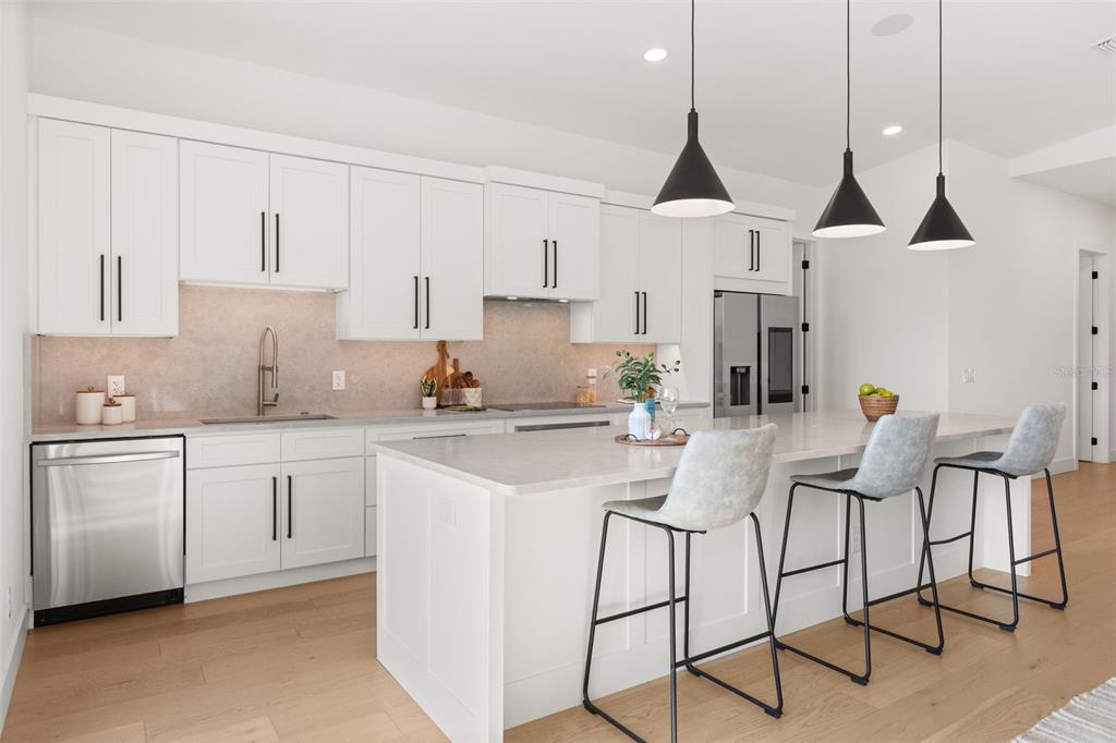 A bright, open-concept living area features light wood floors, white walls, and a vibrant orange door — 930 EAST BOULEVARD, WINDERMERE, FL