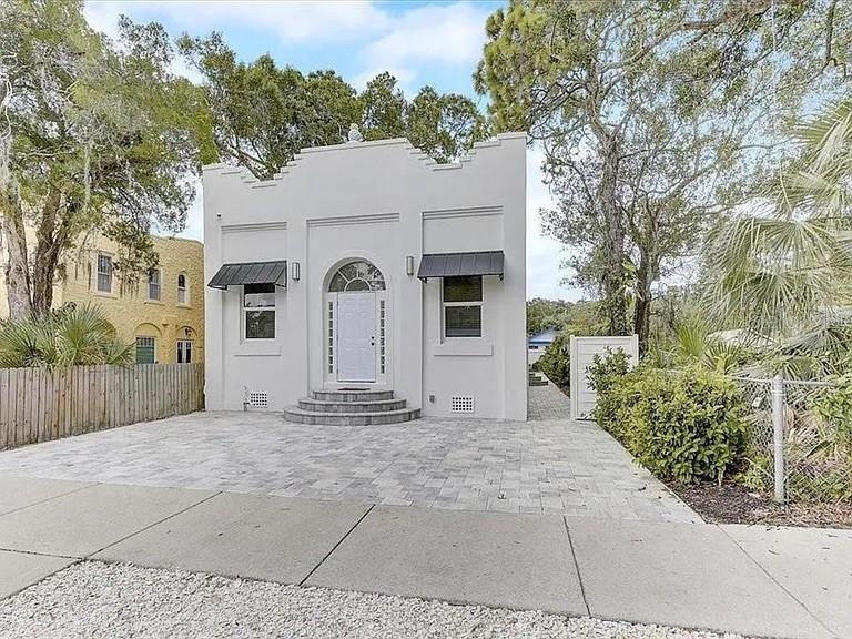 A white, single-story building with a stepped roofline and a paved driveway — 1862 6TH STREET, SARASOTA, FL