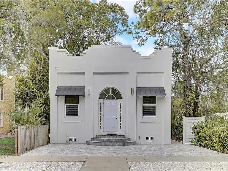 A white, single-story building with a stepped parapet roof and a central arched entryway — 1862 6TH STREET, SARASOTA, FL
