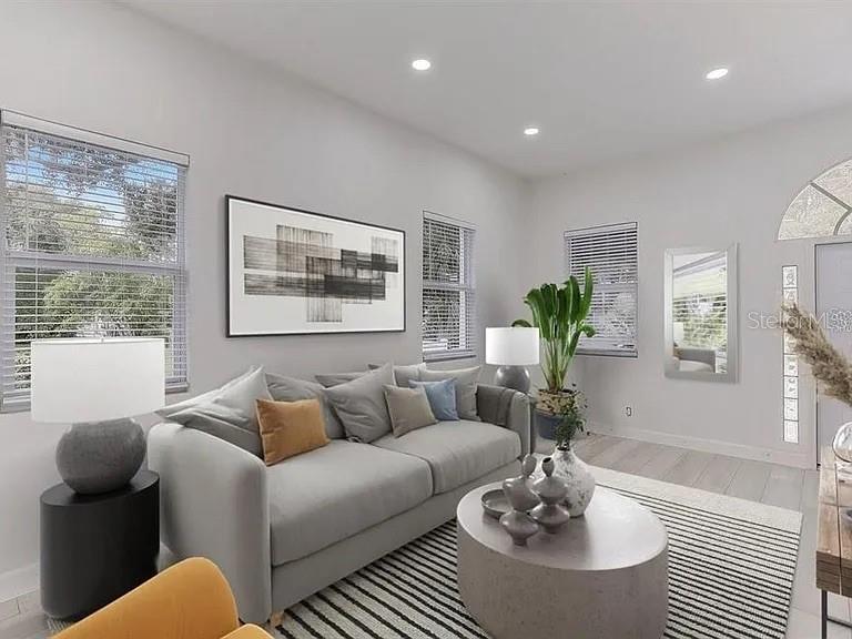 A living room features a gray sofa, a round coffee table, and large windows — 1862 6TH STREET, SARASOTA, FL