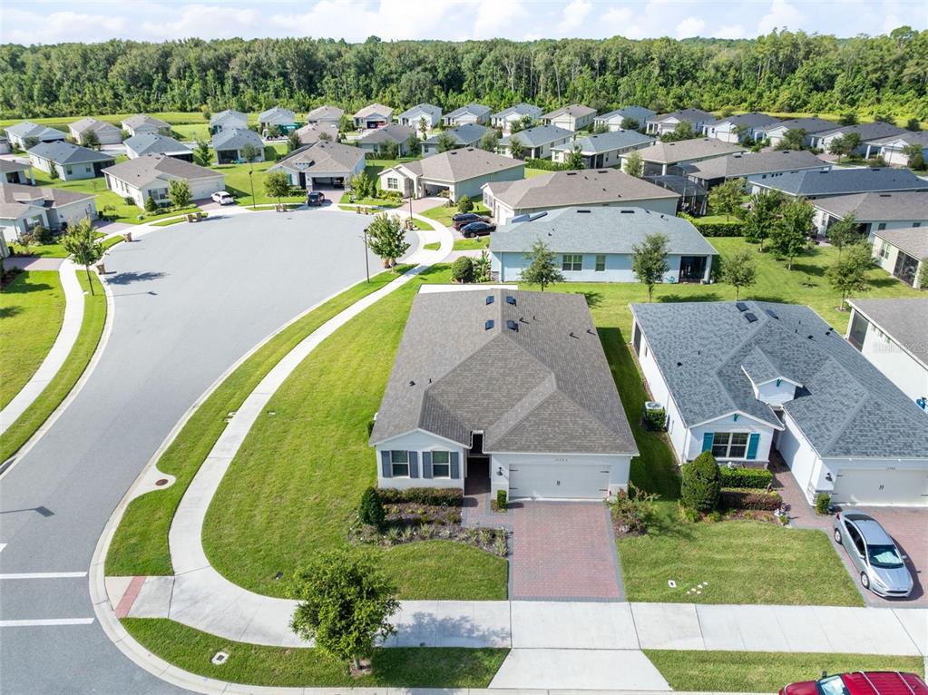 An aerial view shows a suburban neighborhood with single-family homes and a paved cul-de-sac — 17782 BLAZING STAR CIRCLE, CLERMONT, FL