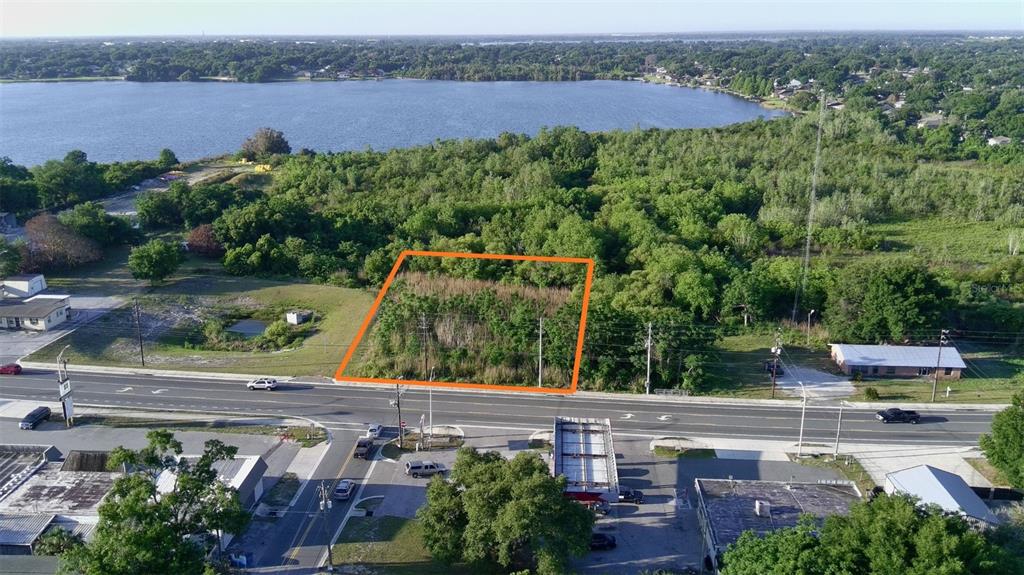 An aerial view shows a rectangular, undeveloped lot outlined in orange next to a road — DUNDEE ROAD, WINTER HAVEN, FL