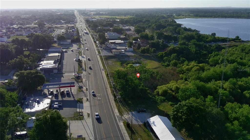 An aerial view shows a road, a gas station, and a wooded lot with a pin — DUNDEE ROAD, WINTER HAVEN, FL