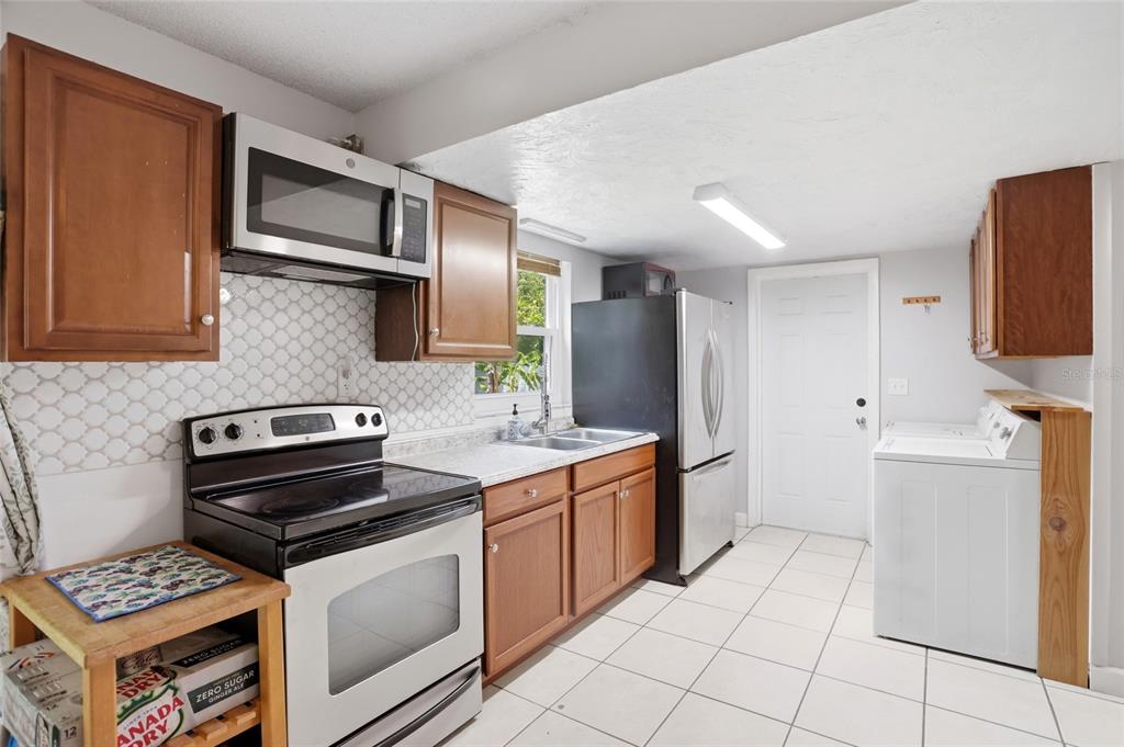 A living room features light tile flooring, a ceiling fan, open shelving, and a large window — 804 ROSALIA DRIVE, SANFORD, FL
