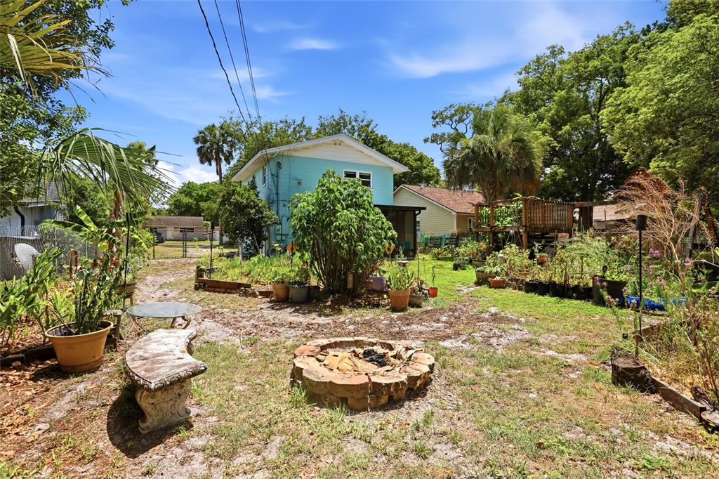 A kitchen featuring wood cabinets, stainless steel appliances, a tiled backsplash, and an adjacent laundry area — 804 ROSALIA DRIVE, SANFORD, FL